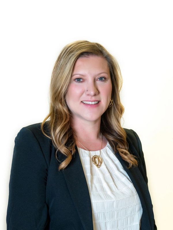 Professional woman in business attire smiling.