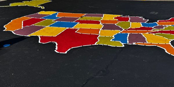 Custom United States map painted on a school playground — Madsen Striping brings creative, precise pavement art to Idaho schools and municipal properties, not just commercial lots.