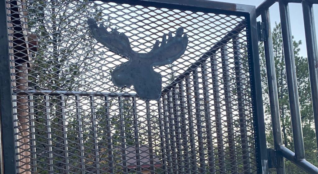 Metal gate with moose art.