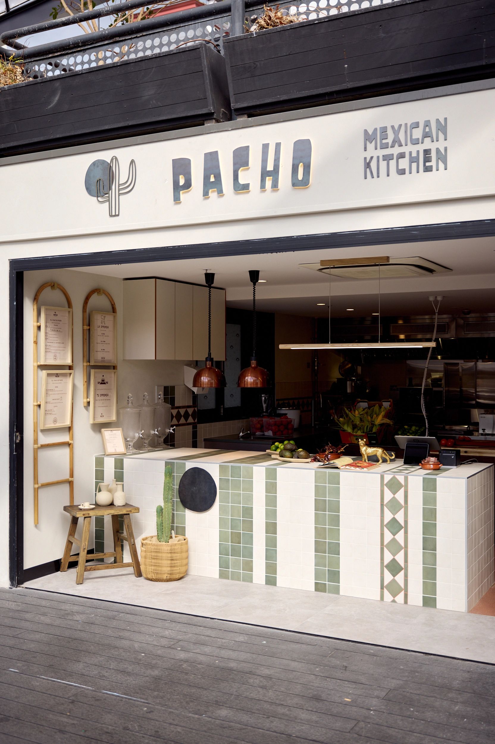 Exterior of Pacho Mexican Kitchen with cactus decor and tiled counter.