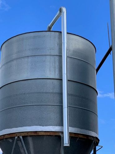 Large industrial silo under clear blue sky.