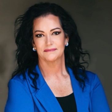 Professional woman in blue blazer posing.