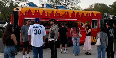 People gathered around a colorful food truck.