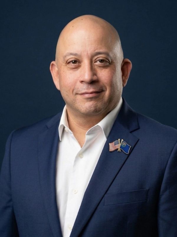 Man in suit with American and Nevada flag pin on lapel.