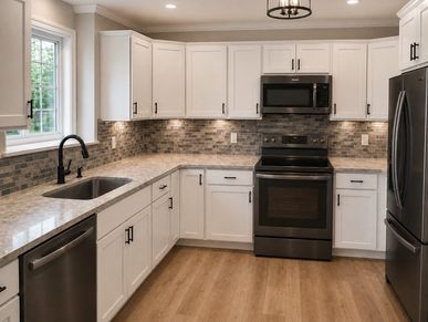 Modern kitchen with white cabinets and stainless steel appliances.