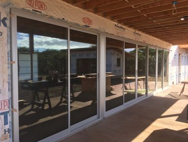 New sliding glass doors installed on a patio under construction.
