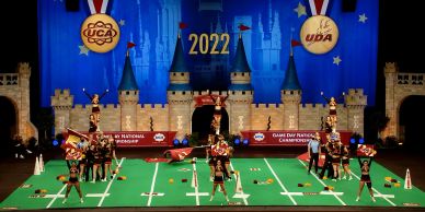 Cheerleading team performing on a decorated football field stage.