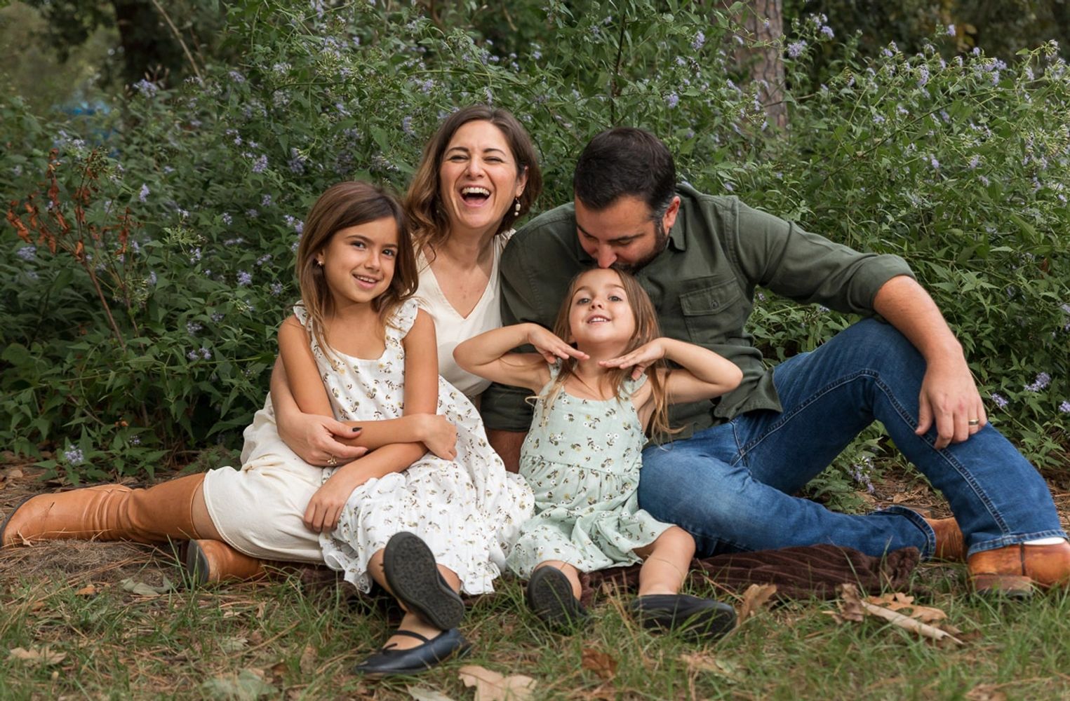Family of four laughing and enjoying an outdoor portrait session in Austin, Texas.