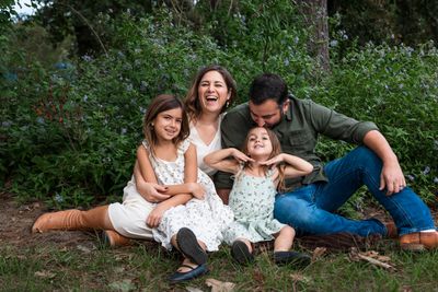 Family of four laughing together during a relaxed outdoor family portrait session in Austin, Texas