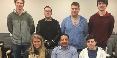 Group photo of seven people indoors.