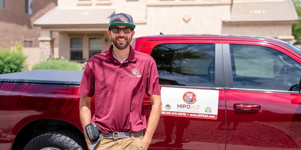 A man wearing red shirt standing near a car