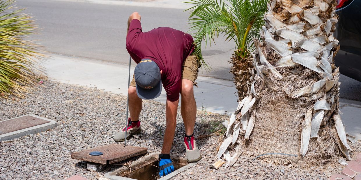 A man picking up something from under the ground