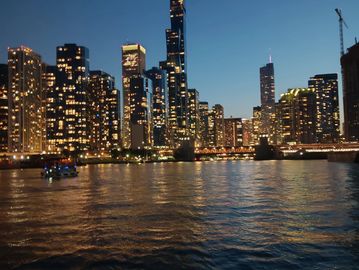 City skyline illuminated at night with reflections on the water.