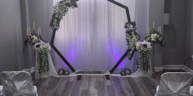 Decorated wedding arch with white and purple flowers.