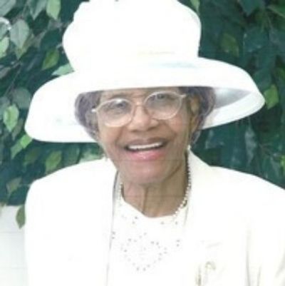 Smiling elderly woman in white hat and glasses.