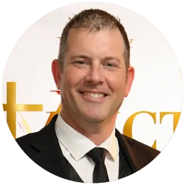 Man in a suit smiling at a formal event.