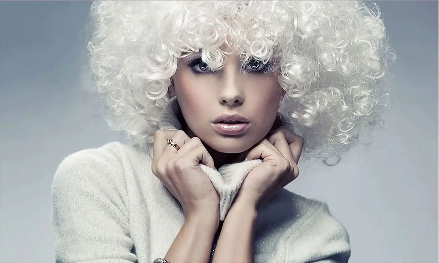 Women with curly hair gently touching her turtleneck sweater