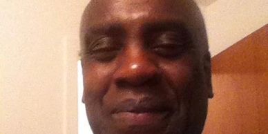 Close-up of a man smiling indoors.