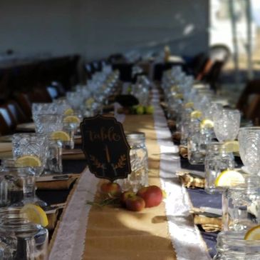 Long table set for event with glasses and lemons.