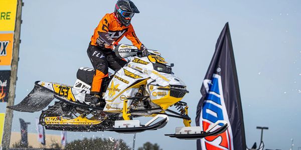 Snowmobile rider airborne during a race.