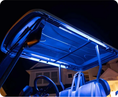 Golf cart illuminated with blue neon lights at night.