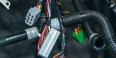 Close-up of a vehicle wiring harness with multiple connectors and colored wires.