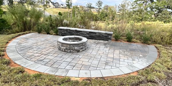 Paver patio with retaining wall seating area and stone fire pit.