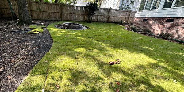 Zoysia sod installation with natural area creation and firepit.