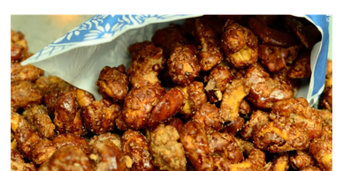 Candied nuts spilling from a blue and white bag.