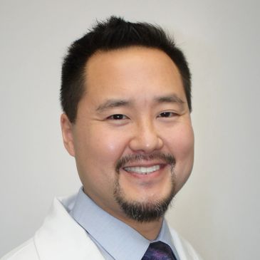 Smiling male doctor in white coat.