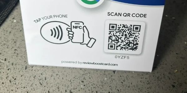 A sign requests Google reviews with NFC tap and QR code options.