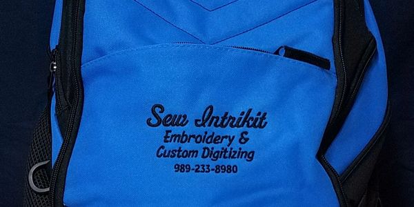 Blue bag with custom embroidery and digitizing service details.