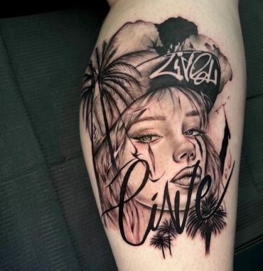 Black and grey tattoo of a woman with palm trees and script.