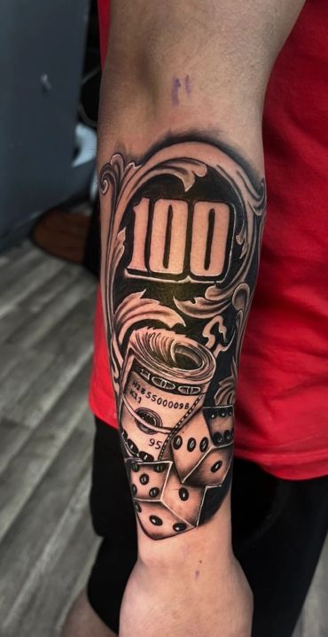 Forearm tattoo with 100, money, and dice elements.