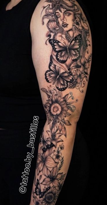Intricate black and gray sleeve tattoo with butterflies, flowers, and a woman's face.