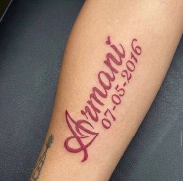 Tattoo with the name 'Armani' and date '07-05-2016' on arm.