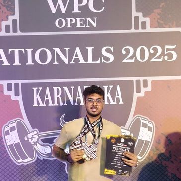 Young man holding medals and certificates at WPC Open Nationals 2025 in Karnataka.