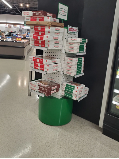 Tower of krispy kreme doughnuts grocery store
donuts stacked in boxes
inside grocery store display