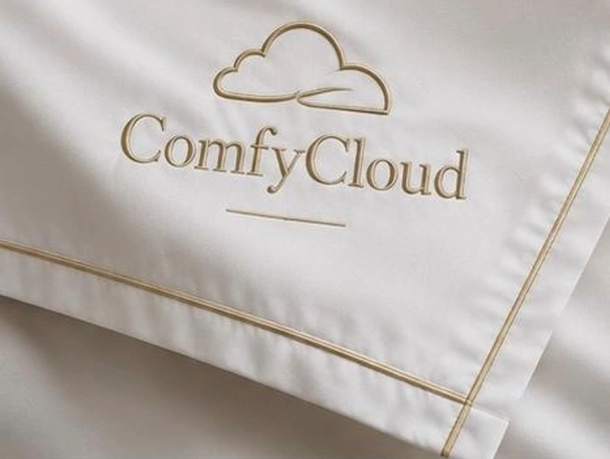 White bedding with the embroidered brand name 'ComfyCloud' and a cloud logo.