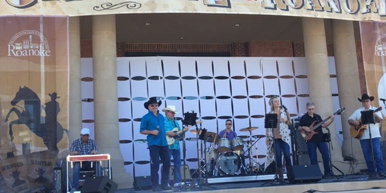 A country band performing on an outdoor stage in Roanoke.