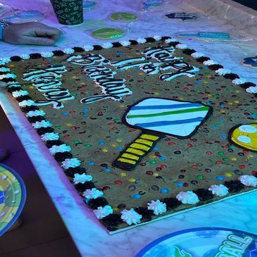 Large cookie cake decorated for a birthday with colorful candy and game icons.