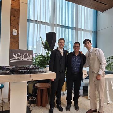Three men in formal attire posing indoors.