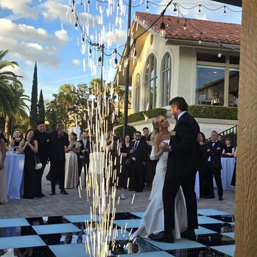 Bride and groom dancing with sparkler fountain at outdoor wedding.