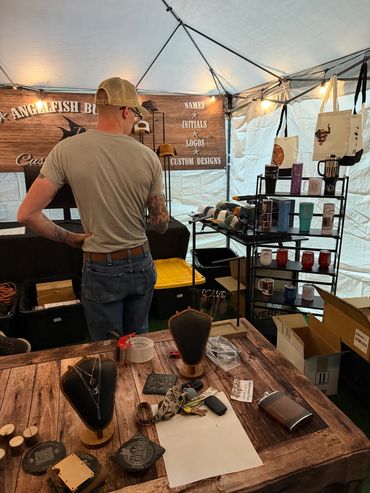 Man browsing a custom design booth at a market.