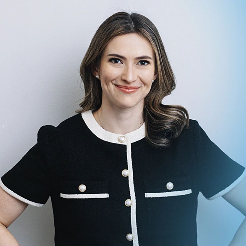 Confident woman smiling, wearing a black and white buttoned top.
