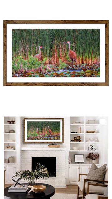 Two sandhill cranes in a wetland framed above a fireplace in a modern living room.