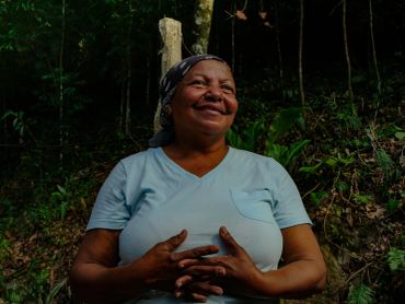 Mujer sonriente en un entorno natural.