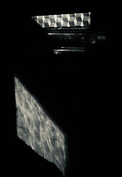 Light patterns cast on a dark surface creating geometric shapes.