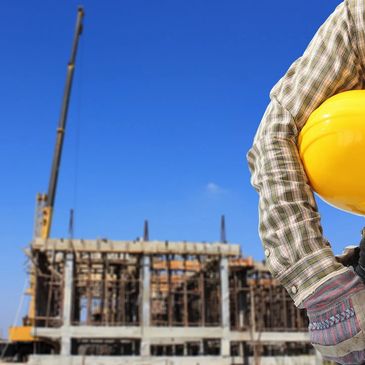 Large crane with construction studs behind construction worker