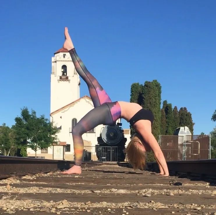Boise Yoga Girl on train tracks in Wheel Pose ini front og the Boise Train Depot